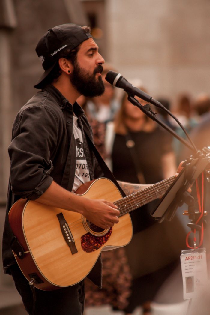 menu-05 A bearded musician singing and playing guitar on a Dublin street.