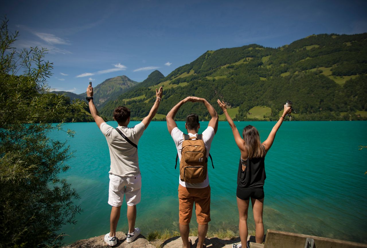 Crafting Captivating Headlines: Your awesome post title goes here Three young adults celebrating by a vibrant turquoise lake surrounded by lush hills.