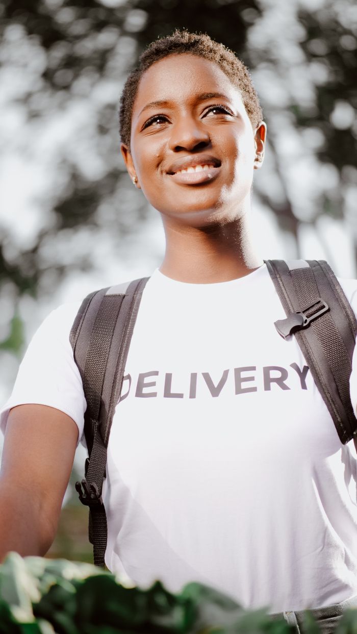 menu-01 Portrait of a cheerful delivery woman in uniform, representing service and efficiency.
