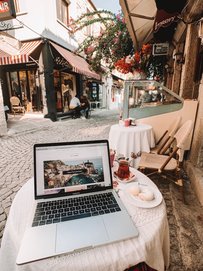 Laptop on table at a charming café in cobblestoned streets of Alaçatı, İzmir.